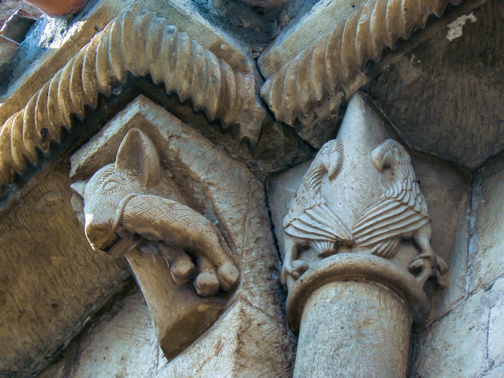 Canecillo con un lobo devorando una oveja en el extremo este de la fachada del monasterio San Pedro de Tejada en la localidad burgalesa de Puentearenas
