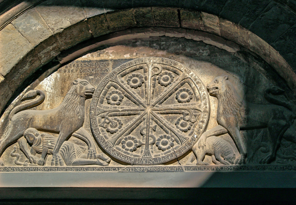 Crismon flanqueado por sendos leones en el timpano de la portada de la catedral de la localidad aragonesa de Jaca