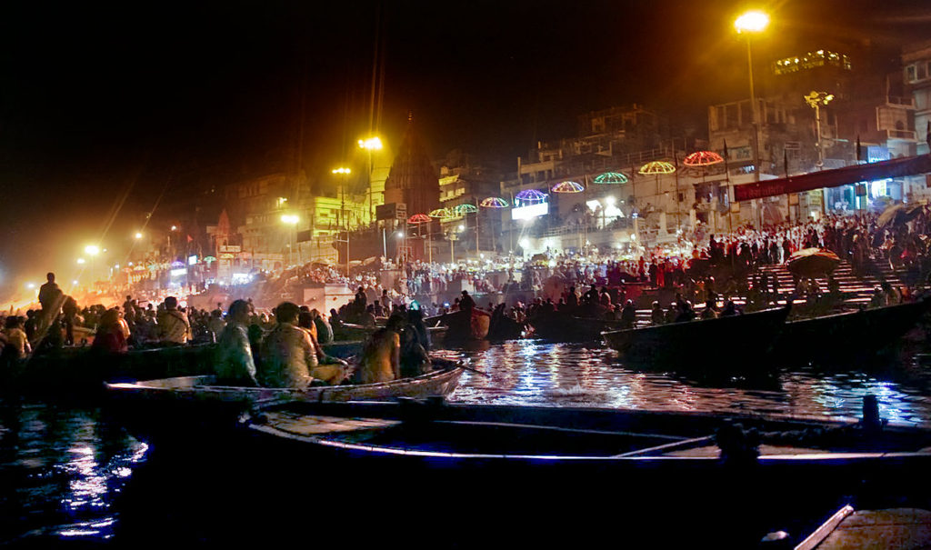 El turismo internacional observa los rituales nocturnos del Ganges desde sus barcas