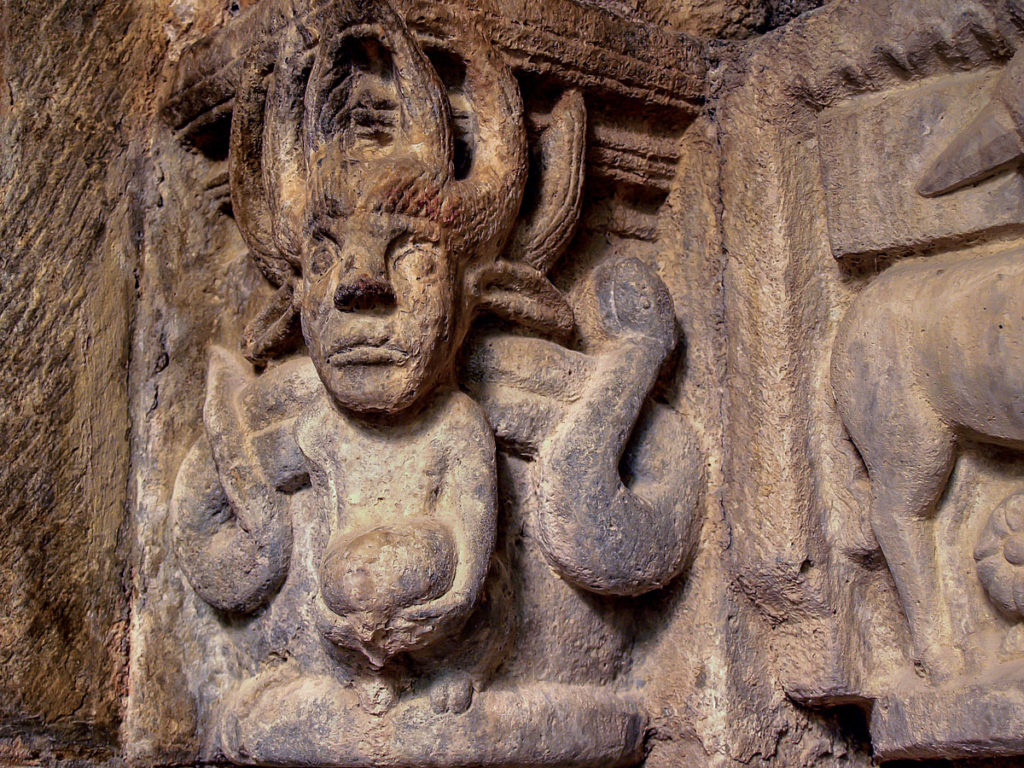 Demonio de erizada cabellera flamigera y escoltado por serpientes en uno de los capiteles interiores de la iglesia de Santa Maria de Siones Burgos