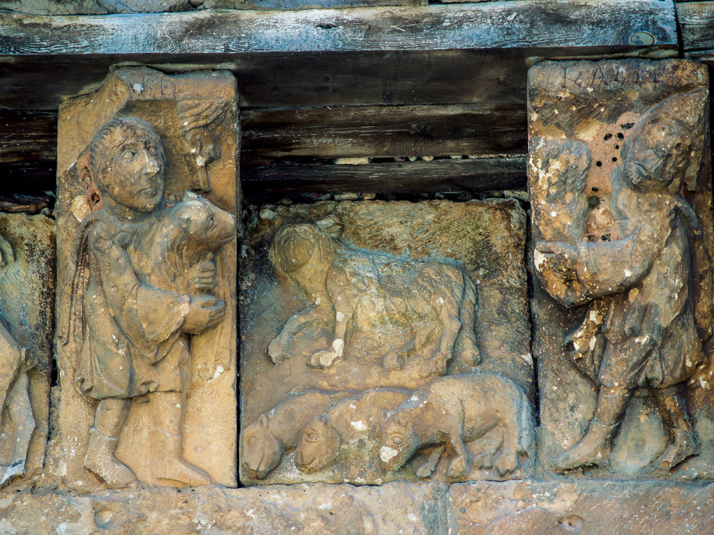 Canecillos y metopas representando las ofrendas de un cordero y una gavilla de espigas de trigo a Yahveh por parte de Abel y Cain respectivamente en la abadia de San Quirce Burgos